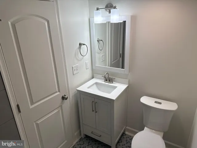 a bathroom with a sink a toilet a mirror and vanity