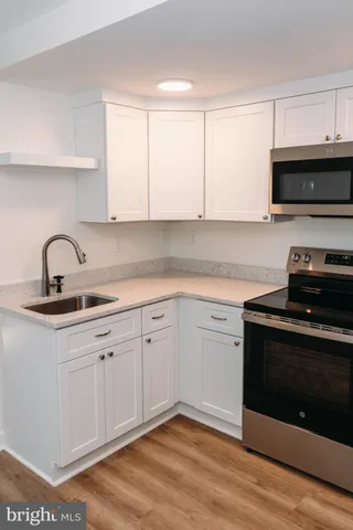 a kitchen with stainless steel appliances granite countertop a sink dishwasher a stove and a microwave oven with cabinets