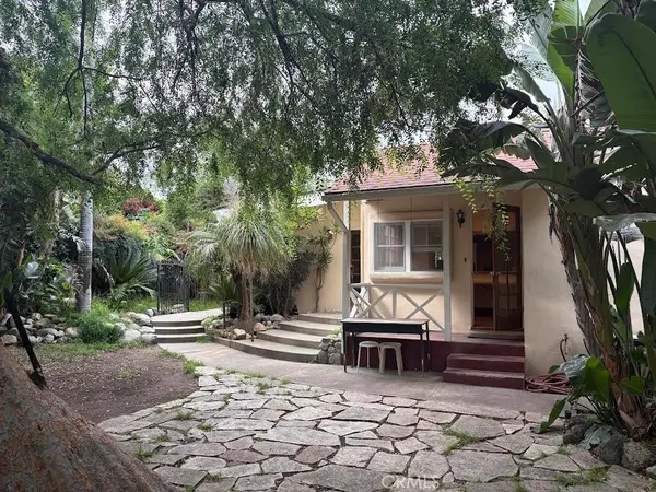 a view of house with backyard and sitting area