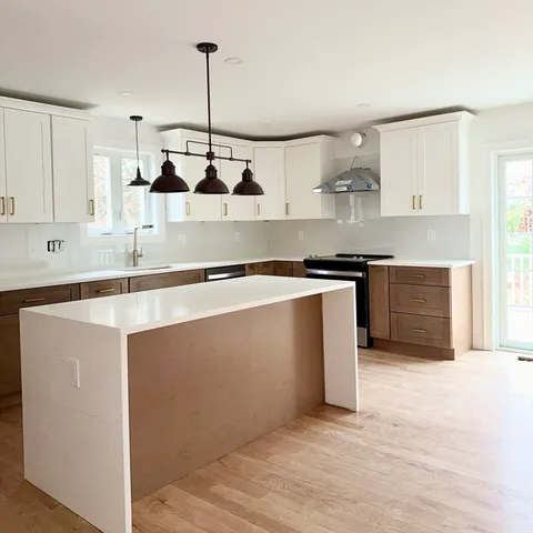 a kitchen with stainless steel appliances granite countertop a sink a stove and a refrigerator