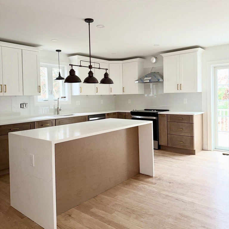 580 Broad Street, Unit 2 Bridgewater, MA 02324 - Photo 4 of 16 a kitchen with stainless steel appliances granite countertop a sink a stove and a refrigerator