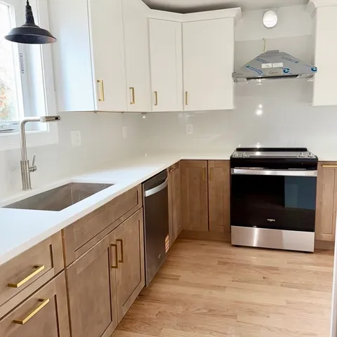 a kitchen with stainless steel appliances granite countertop a stove a microwave and a white cabinets