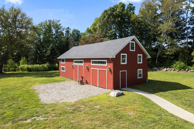 a front view of a house with yard and tree