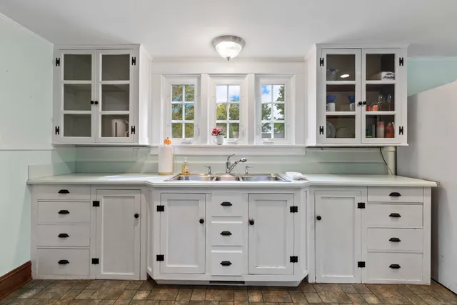 a kitchen with cabinets appliances and a window