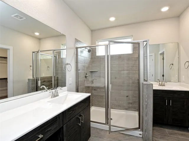 a bathroom with a shower sink double vanity and mirror