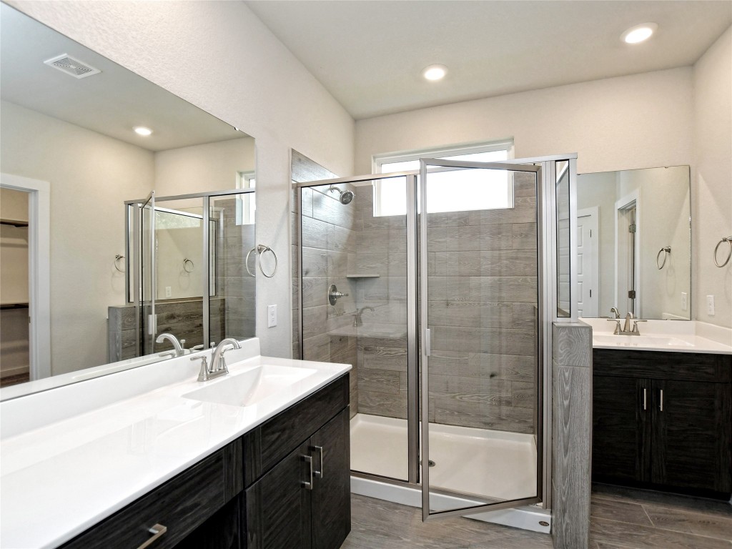 1016 Paddock Lane Georgetown, TX 78626 - Photo 20 of 25 a bathroom with a shower sink double vanity and mirror
