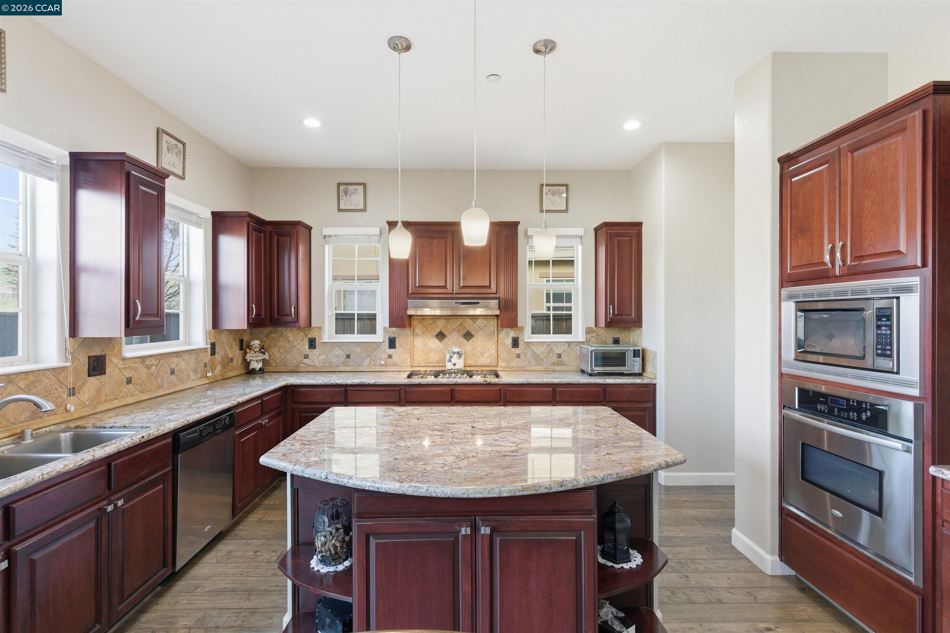 9927 Reimers Way Dublin, CA 94568 - Photo 21 of 39 a kitchen with stainless steel appliances granite countertop a sink and dishwasher a oven with wooden cabinets