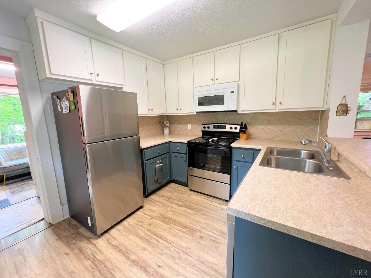 514 Smith Road Hurt, VA 24563 - Photo 14 of 59 a kitchen with granite countertop a refrigerator sink and white cabinets