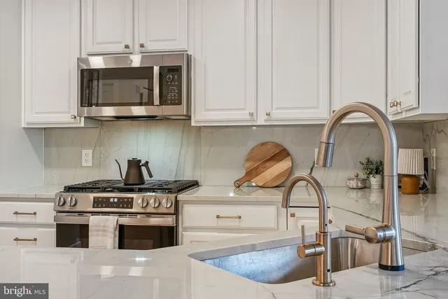 a kitchen with stainless steel appliances granite countertop a stove a sink and a microwave