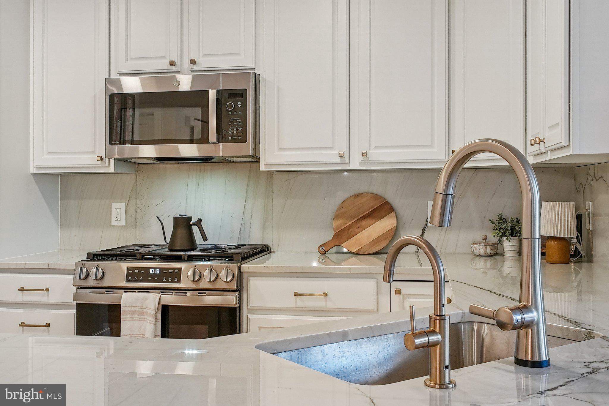 502 West Broad Street, Unit 215 Falls Church, VA 22046 - Photo 11 of 40 a kitchen with stainless steel appliances granite countertop a stove a sink and a microwave