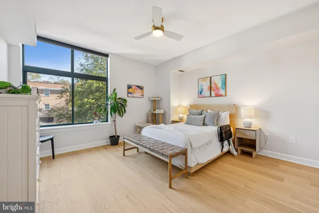 a bedroom with a bed and a large window