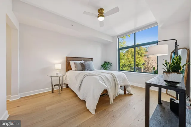 a bedroom with a bed a table and a potted plant