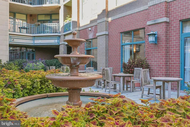 a view of a brick building with a fountain in the patio
