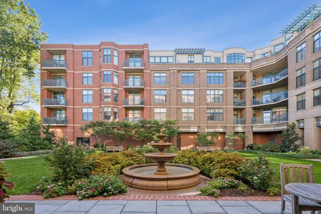 a front view of a building with a garden and plants