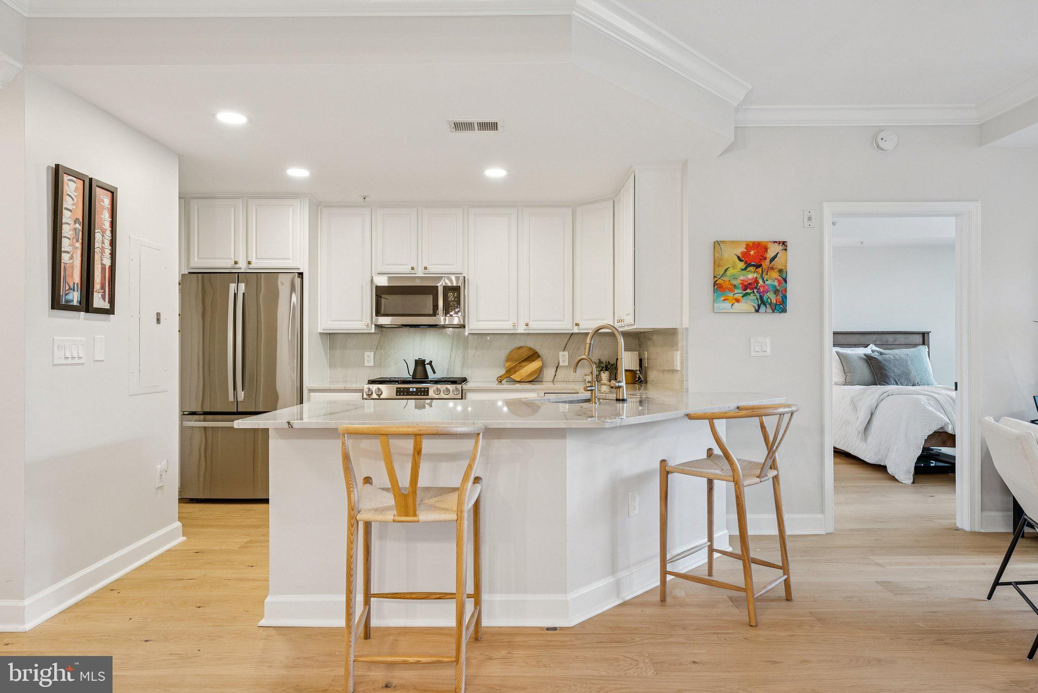 502 West Broad Street, Unit 215 Falls Church, VA 22046 - Photo 4 of 40 a kitchen with stainless steel appliances granite countertop a refrigerator and a stove top oven