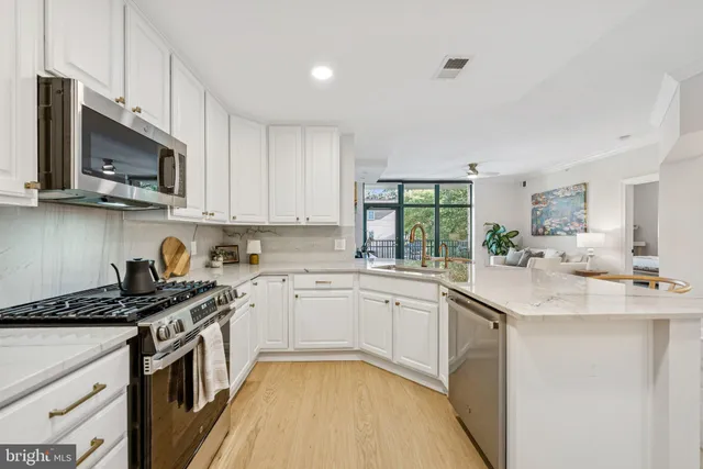 a kitchen with stainless steel appliances granite countertop a sink stove a microwave and cabinets