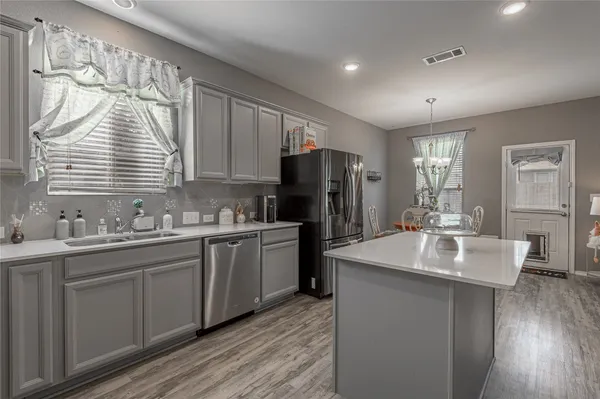 a kitchen with sink refrigerator and cabinets