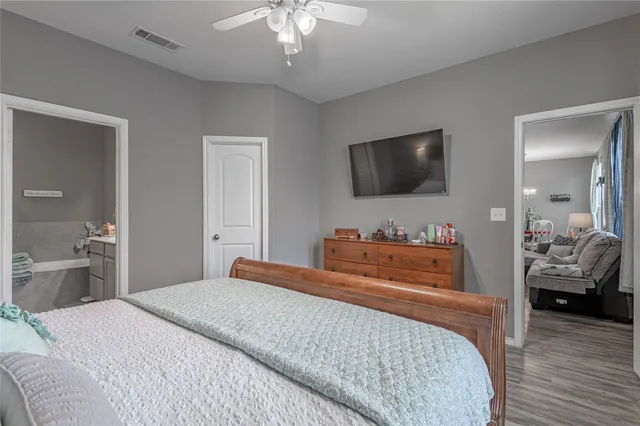 a bedroom with a bed and a flat tv screen on dresser