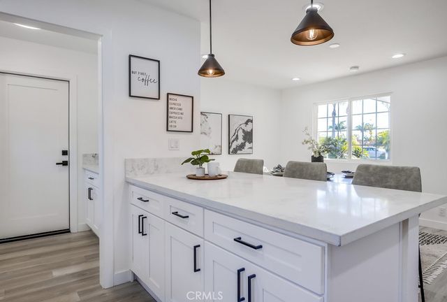 a kitchen with stainless steel appliances kitchen island granite countertop a sink a stove a refrigerator and cabinets