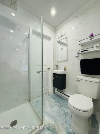 a bathroom with a sink a toilet and shower