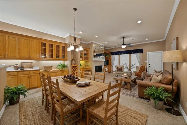 a view of a dining room and livingroom with furniture wooden floor a rug a painting and a chandelier