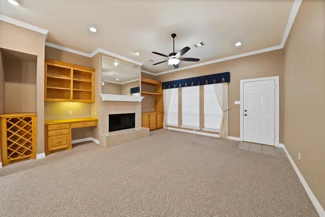a view of an empty room with a fireplace and a window