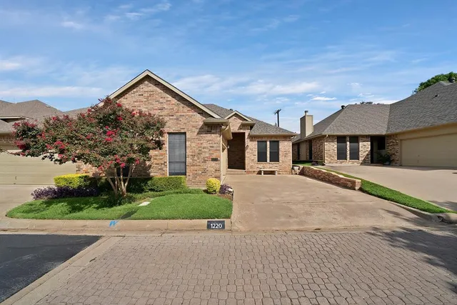 a view of a house with a yard and large tree