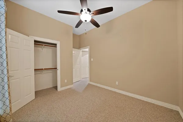 an empty room with closet and windows