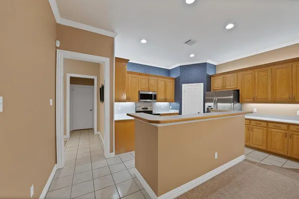 a kitchen with stainless steel appliances a refrigerator and a stove top oven