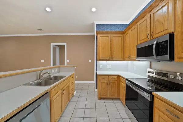 a kitchen with a sink stove top oven and refrigerator