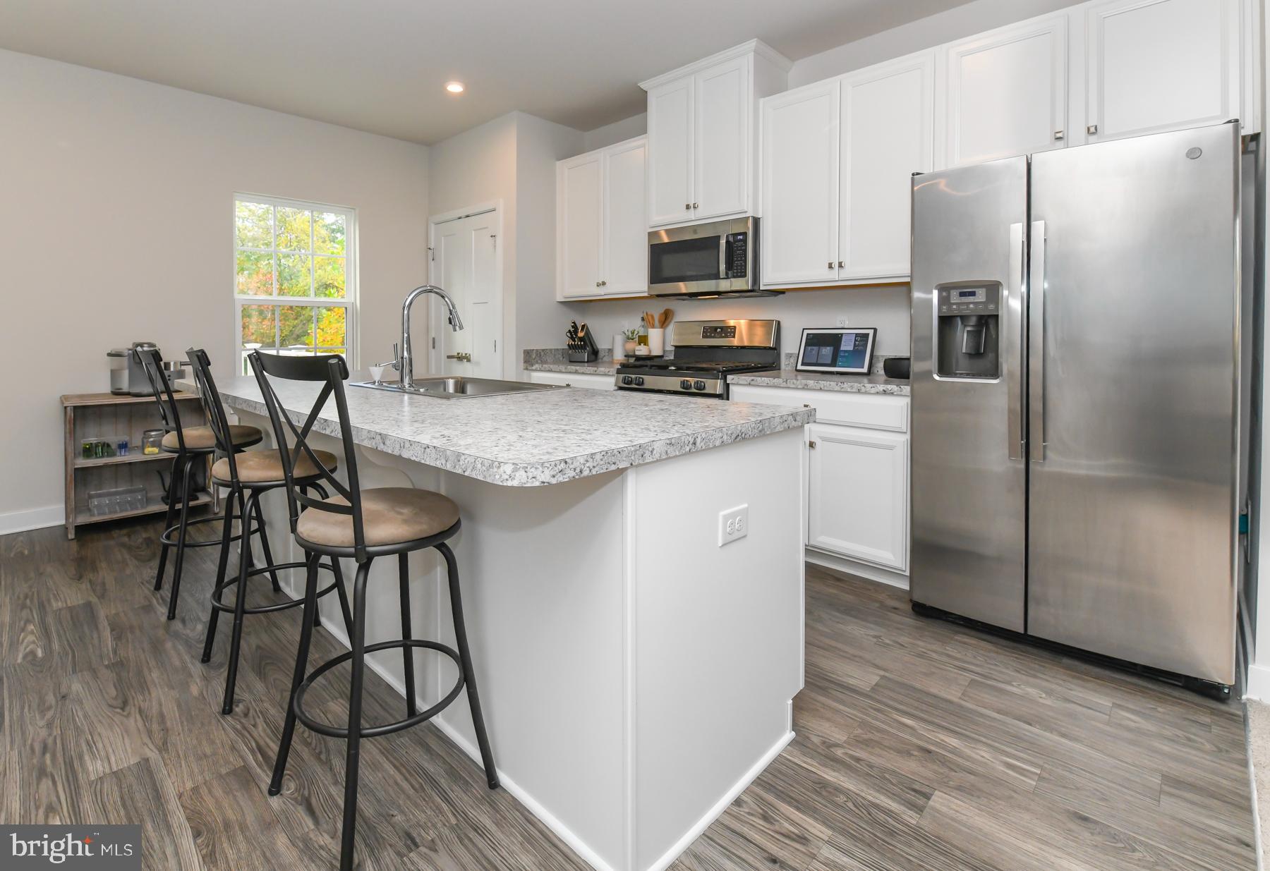 28 Peacock Circle Sewell, NJ 08080 - Photo 8 of 25 a kitchen with stainless steel appliances granite countertop a refrigerator a stove a sink a dining table and chairs with wooden floor
