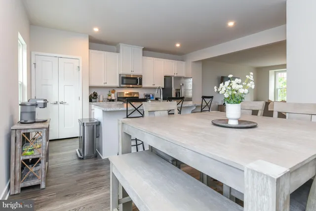 a kitchen with a table chairs refrigerator and microwave