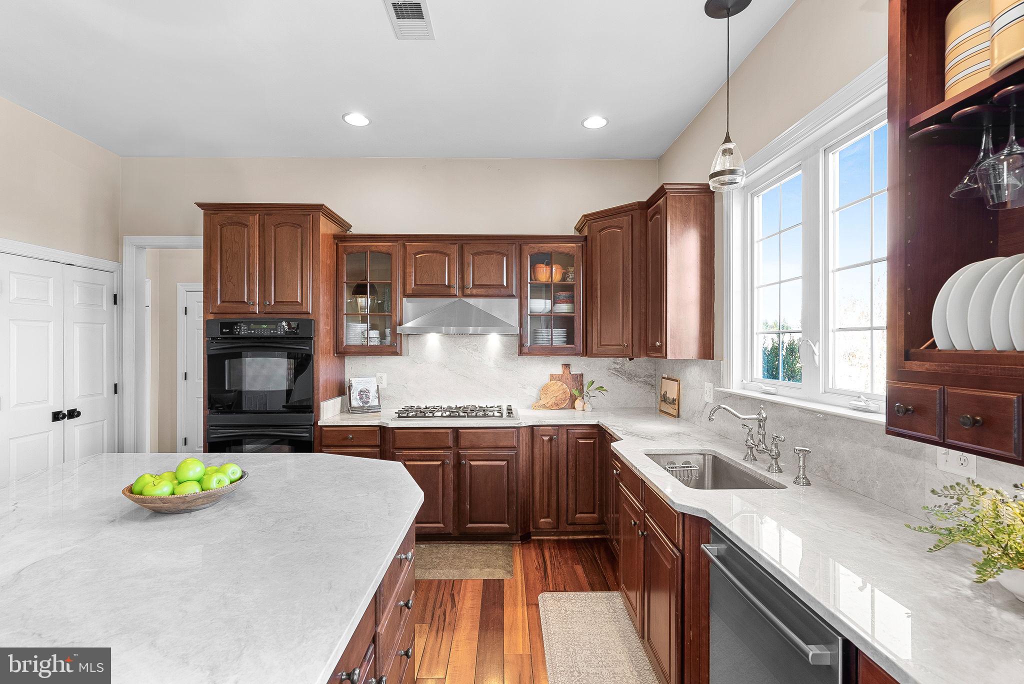 38590 Bettis Drive Hamilton, VA 20158 - Photo 33 of 97 a kitchen with kitchen island granite countertop wooden cabinets a stove a sink a oven a dining table and chairs