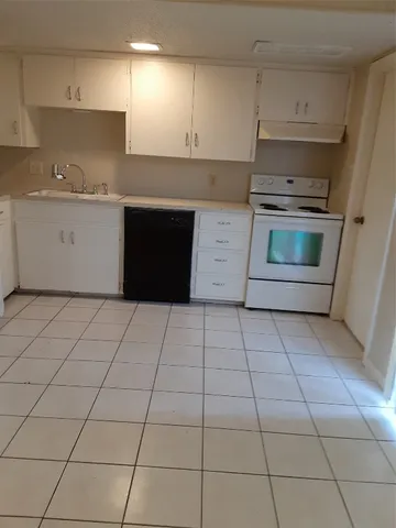 a kitchen with a stove top oven and cabinets