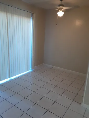 an empty room with a chandelier fan