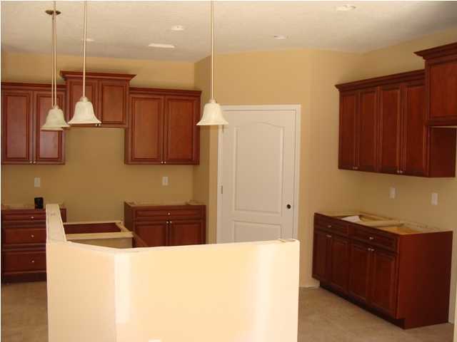 614 Lang Road Fort Walton Beach, FL 32547 - Photo 4 of 7 a kitchen with stainless steel appliances granite countertop a refrigerator and wooden cabinets
