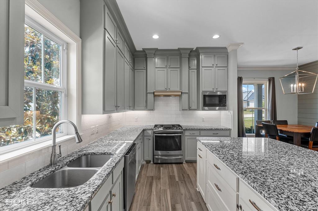 143 Oak Alley Road Stonewall, LA 71078 - Photo 17 of 38 Kitchen featuring grey cabinetry, stainless steel appliances, granite countertops, and wood-finish flooring