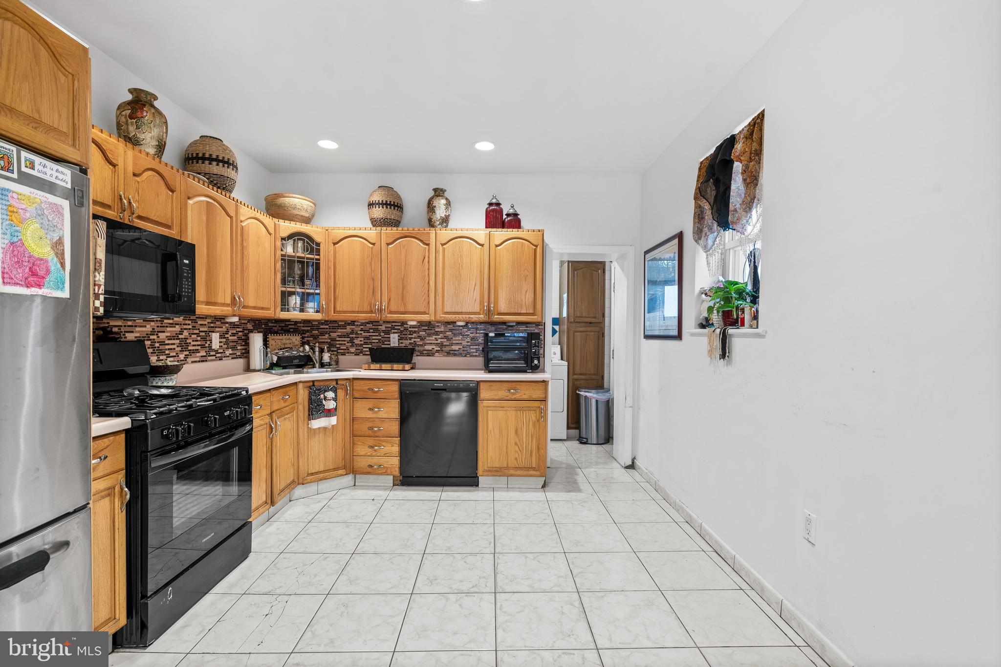 1605 Wolf Street Philadelphia, PA 19145 - Photo 11 of 40 a kitchen with stainless steel appliances granite countertop a stove a sink and a refrigerator