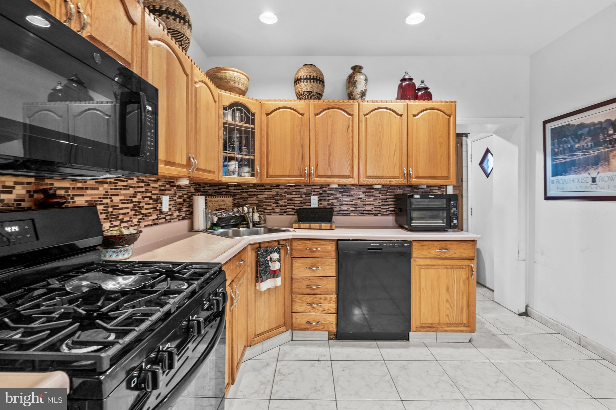 1605 Wolf Street Philadelphia, PA 19145 - Photo 12 of 40 a kitchen with stainless steel appliances a stove and a sink