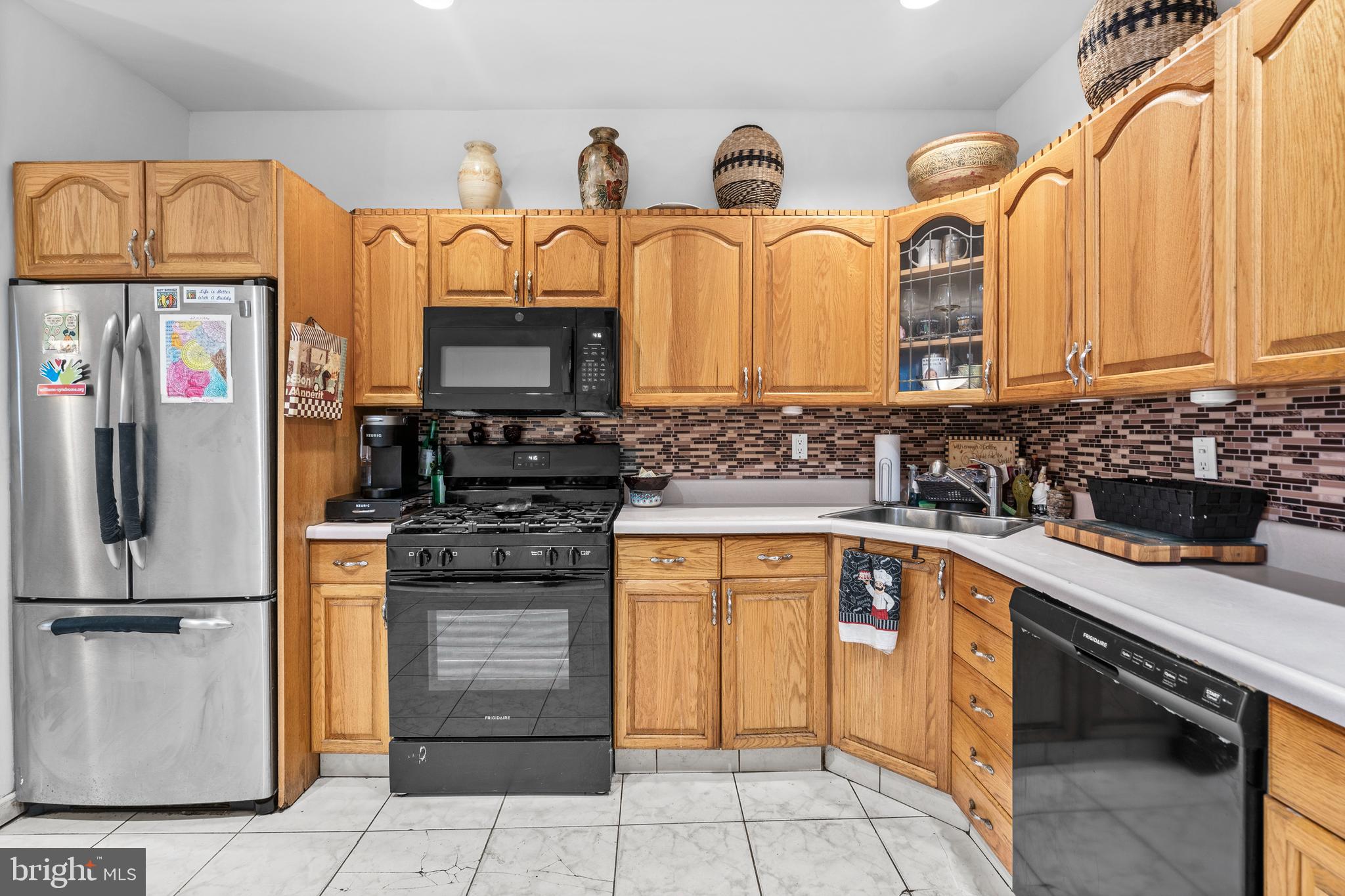 1605 Wolf Street Philadelphia, PA 19145 - Photo 13 of 40 a kitchen with stainless steel appliances a stove sink and cabinets