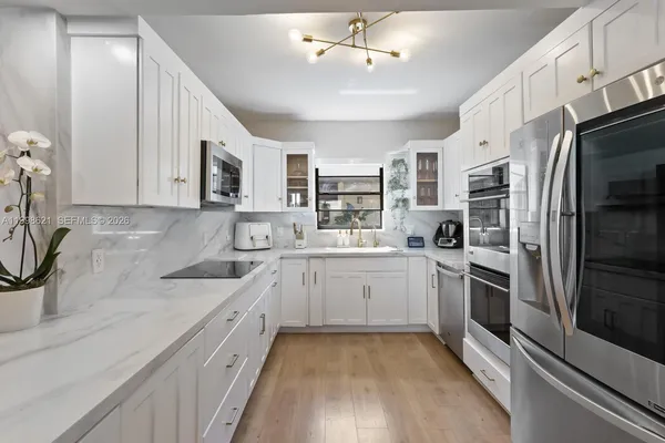 a kitchen with white cabinets and stainless steel appliances