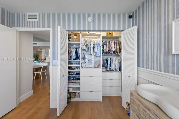 a view of walk in closet with wooden floor