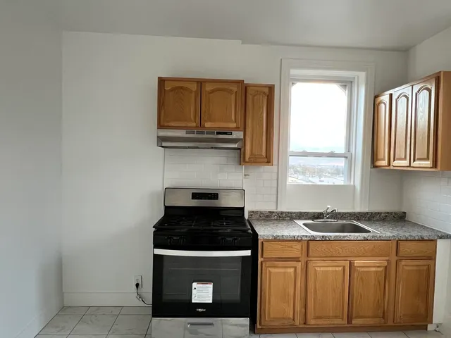a kitchen with granite countertop a stove a sink and a microwave