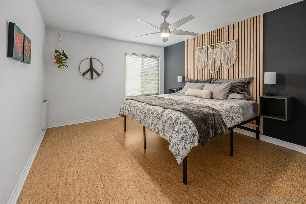 5946 Rancho Mission Road, Unit 160 San Diego, CA 92108 - Photo 12 of 31 a bedroom with a bed a table and painting on the wall