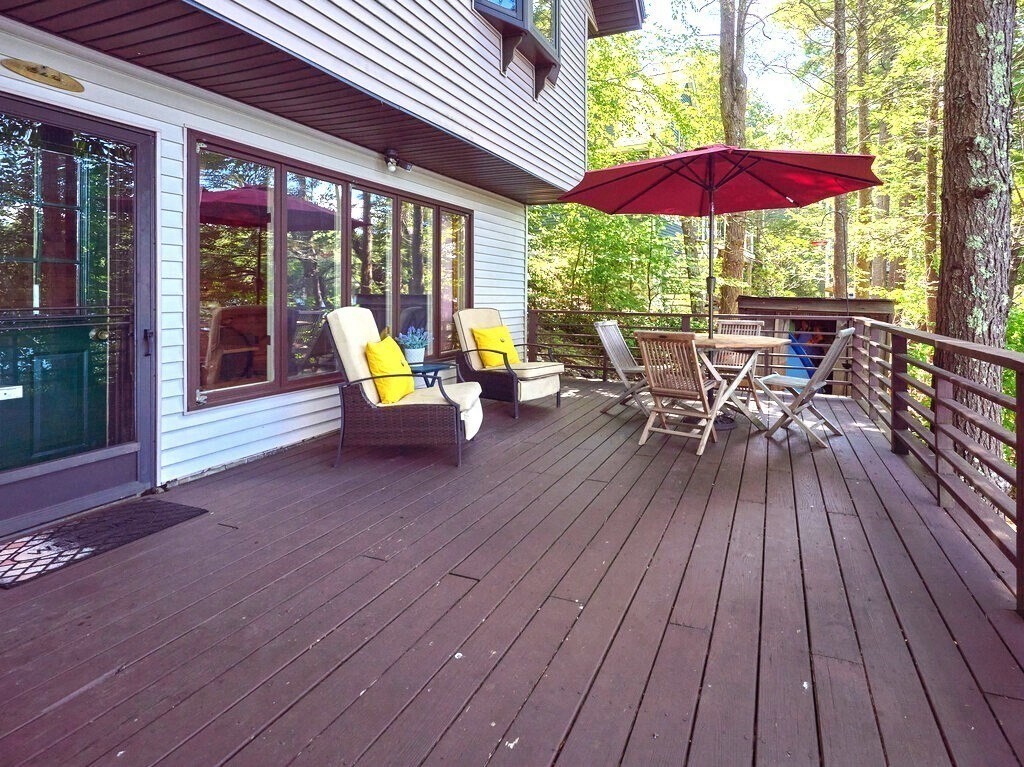 61 Bennetts Road Sturbridge, MA 01566 - Photo 27 of 42 a view of a patio with table and chairs under an umbrella with wooden floor
