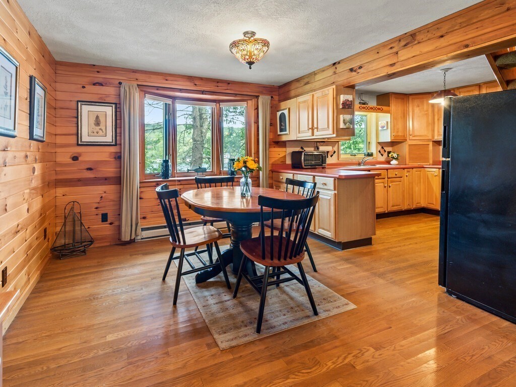 61 Bennetts Road Sturbridge, MA 01566 - Photo 9 of 42 a dining room with furniture a rug a potted plant and a chandelier