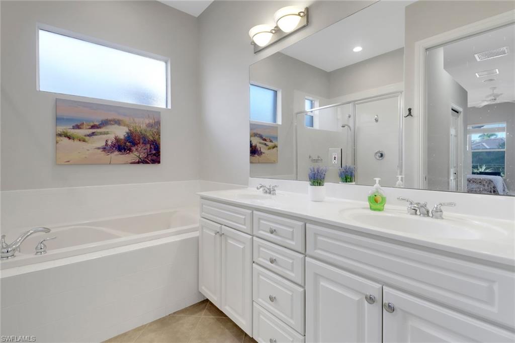 6757 Bent Grass Drive Naples, FL 34113 - Photo 14 of 27 a bathroom with a bathtub a sink and a mirror