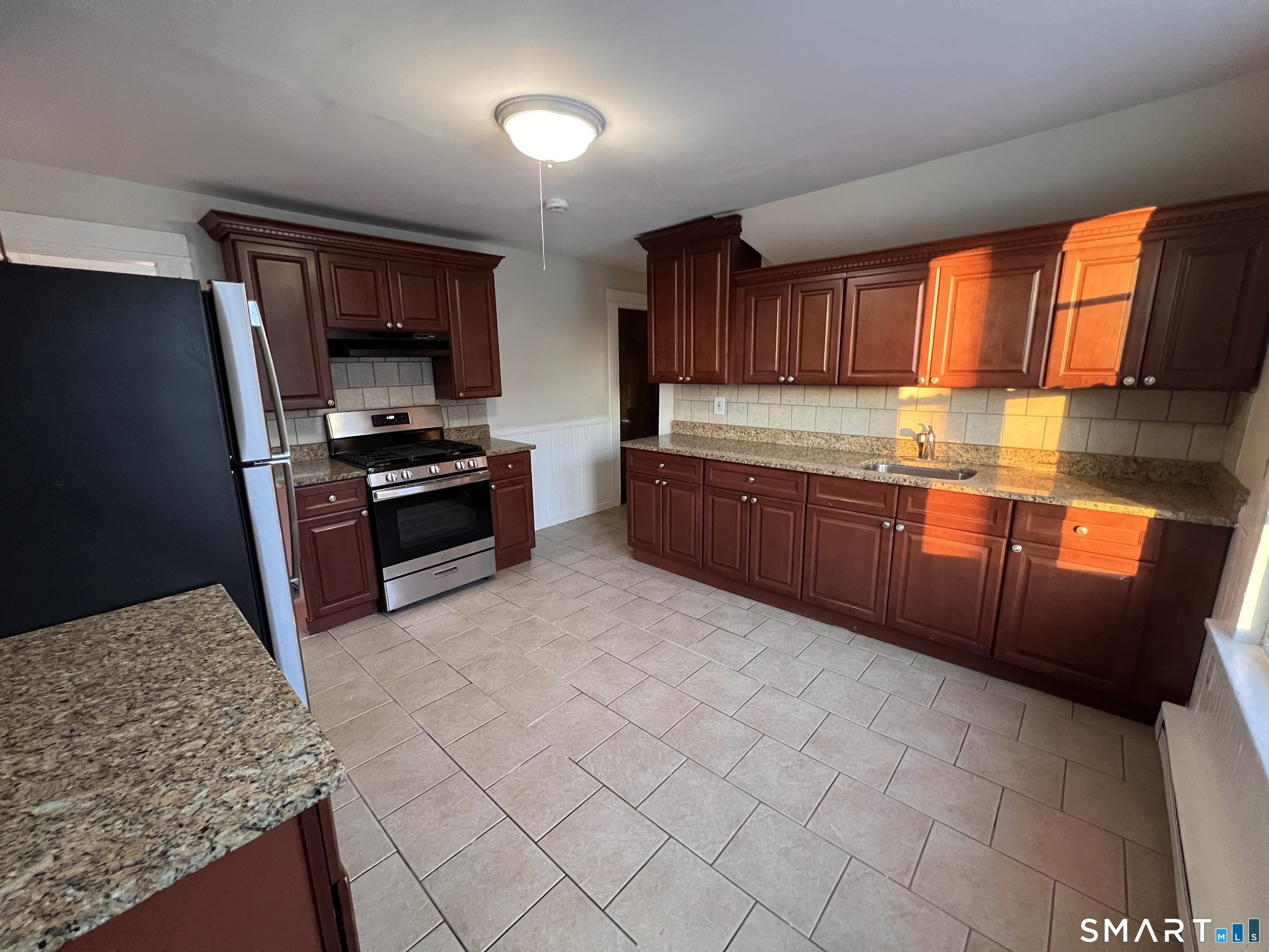 128 Prince Street Bridgeport, CT 06610 - Photo 14 of 19 a kitchen with stainless steel appliances granite countertop a stove a sink and a microwave