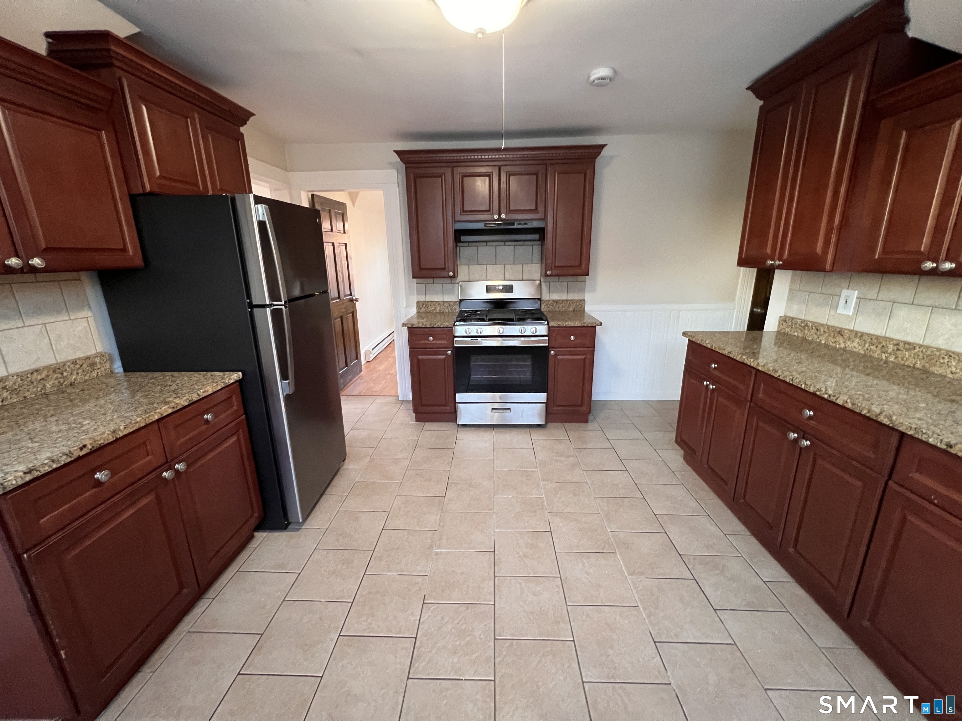 128 Prince Street Bridgeport, CT 06610 - Photo 15 of 19 a large kitchen with stainless steel appliances granite countertop a stove refrigerator and a sink