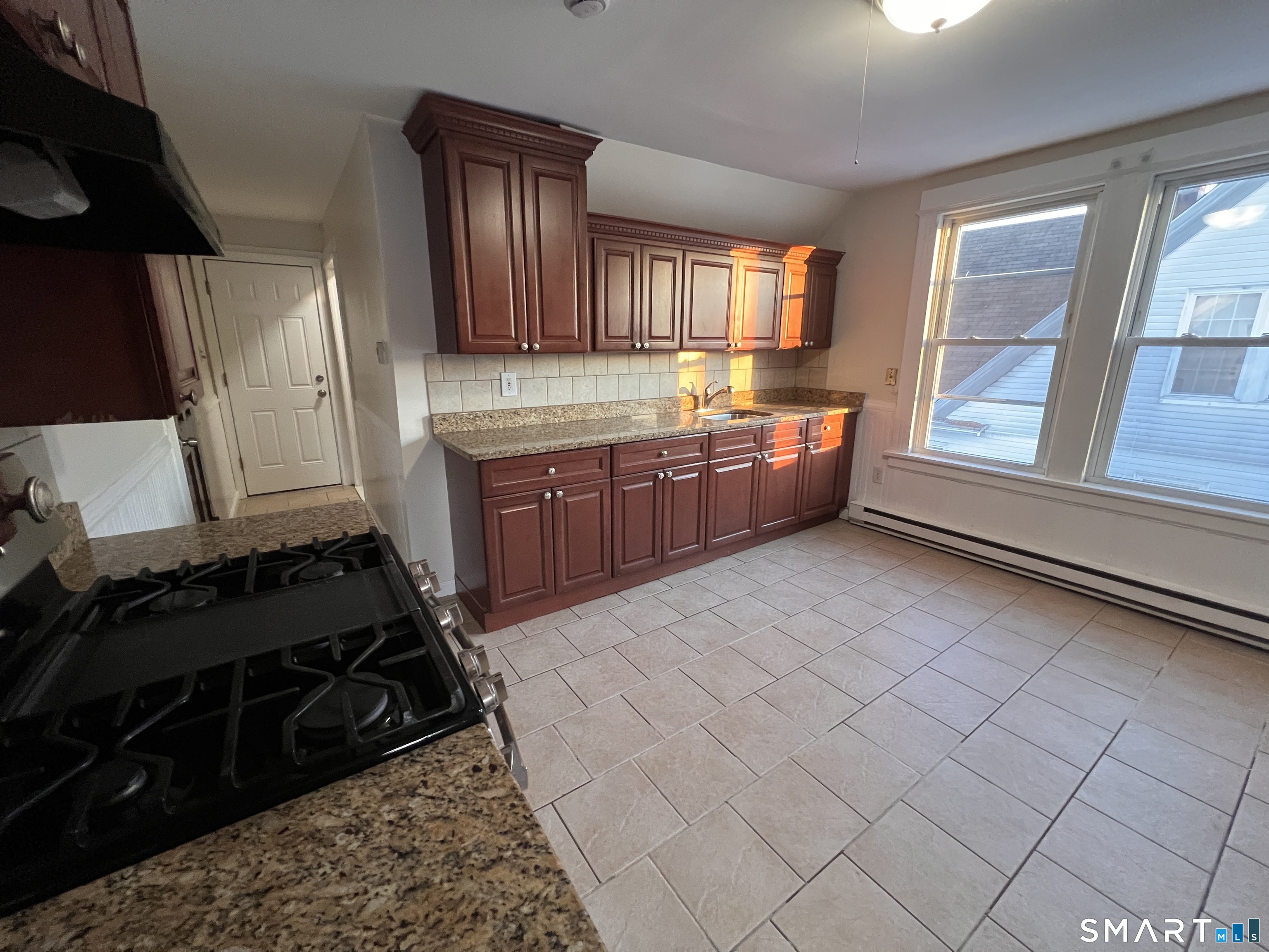128 Prince Street Bridgeport, CT 06610 - Photo 16 of 19 a kitchen with granite countertop a stove and cabinets